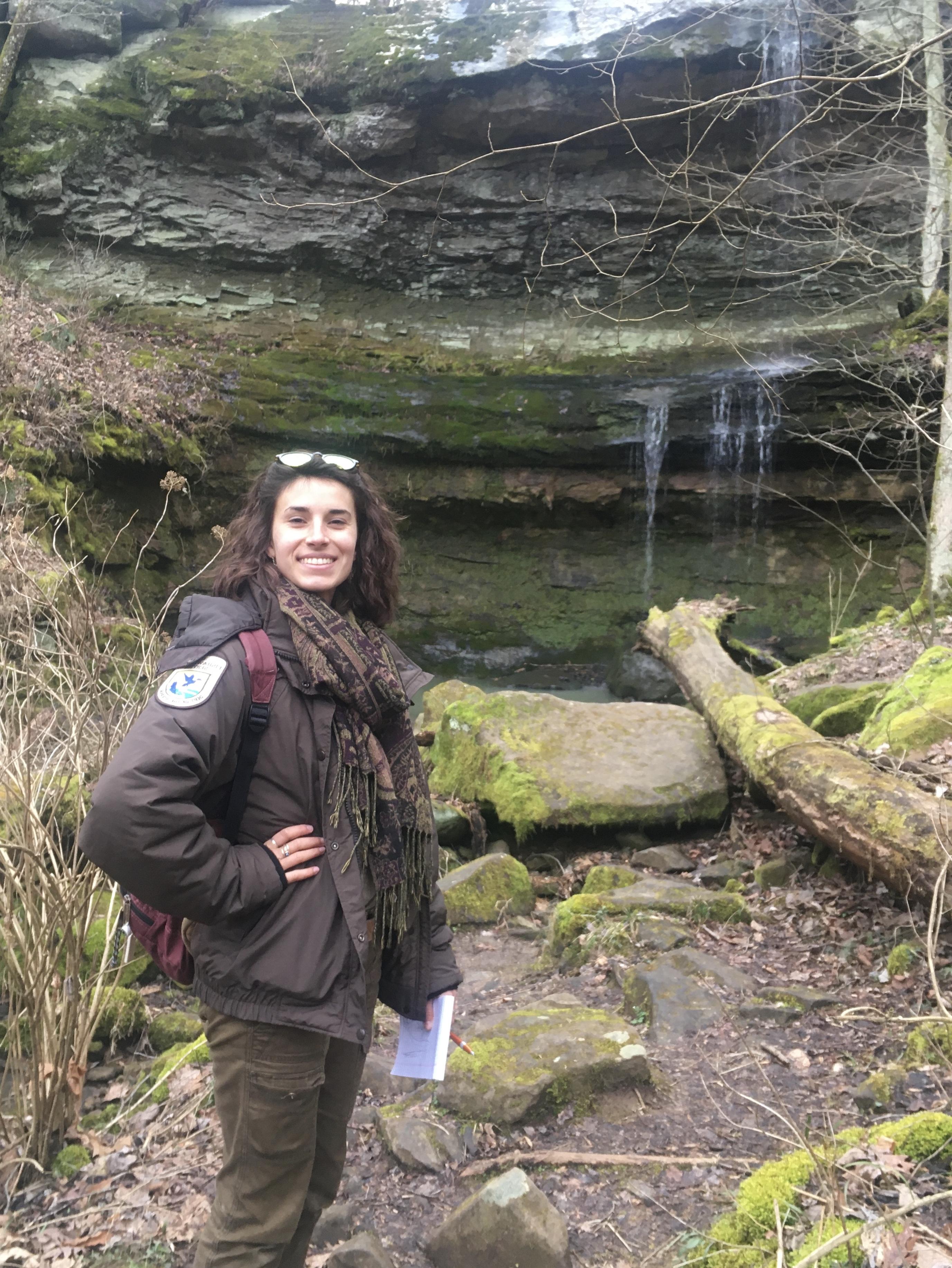 Kyra Neal standing in front of rocks in a forest