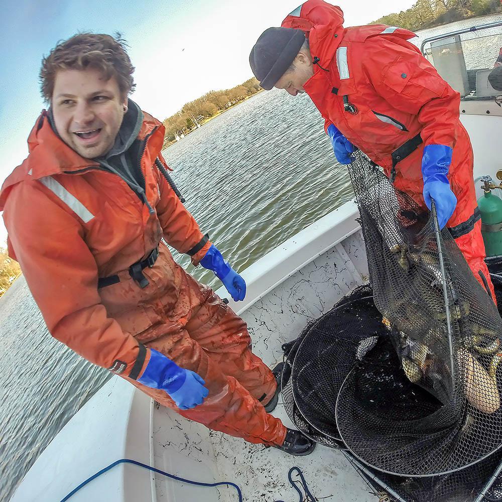 Two men in orange jumpsuits on a boat