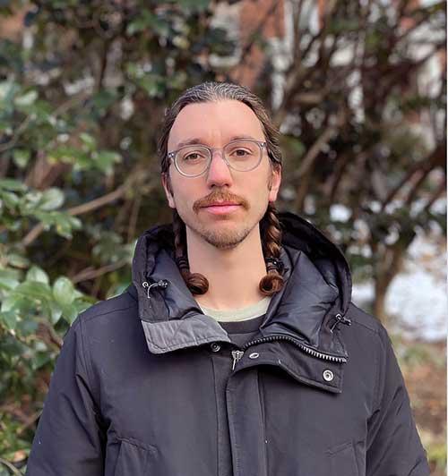 Nick Stavely standing in front of a tree