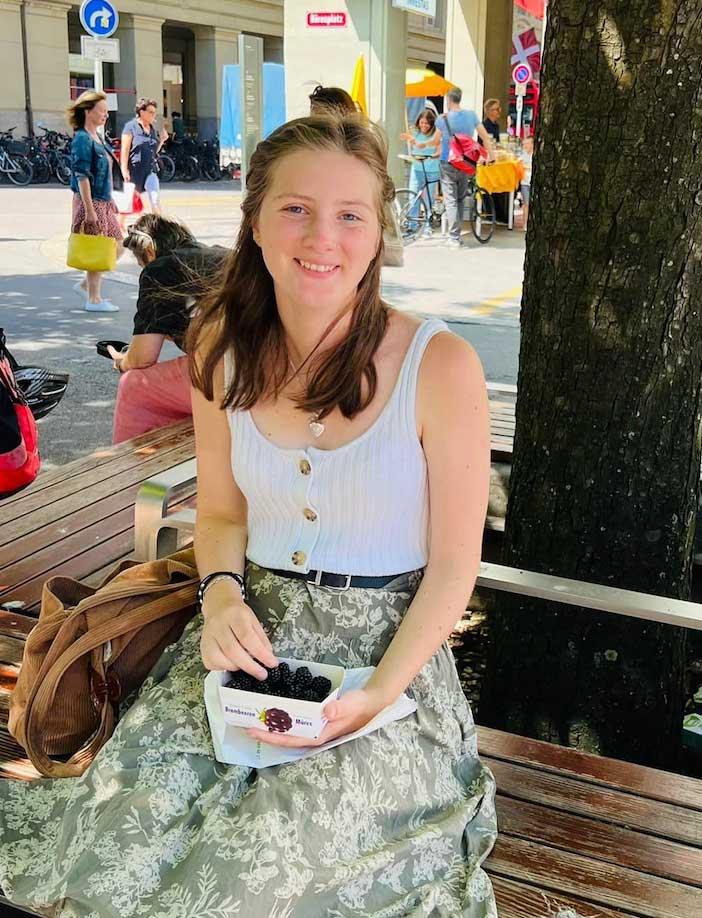 Happy student enjoying a freshly picked pint of blackberries.