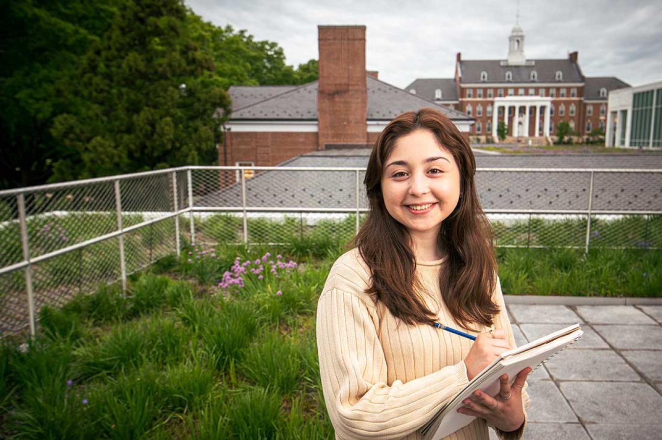 Student on a rooftop with a sketch pad